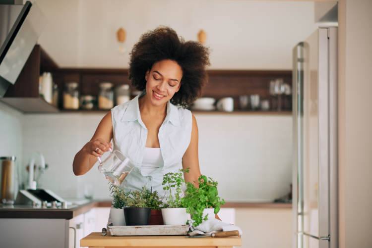 Woman maintaining healthy lifestyle with fresh herbs at home representing wellness and self-care