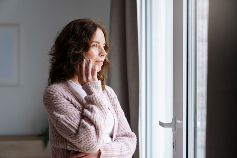 An image of a woman looking serious, while on the phone discussing her options for immediate health insurance