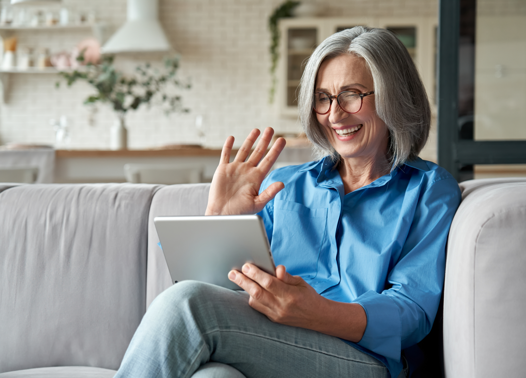An image of a woman who is saying goodbye to colleagues on a video call when she retiring.