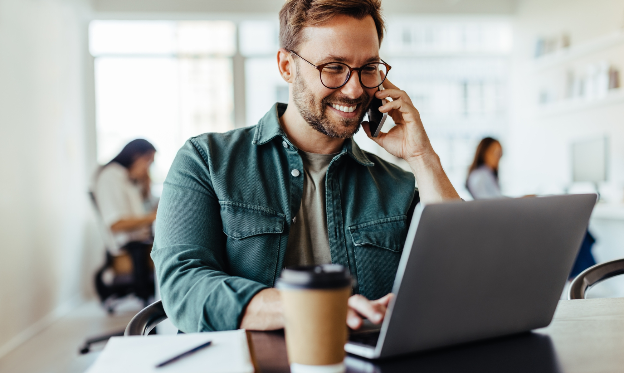 An image of a man on the phone, while researching options for his health insurance